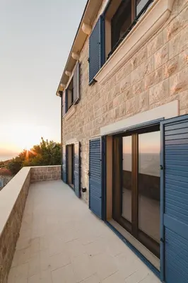 a brick building with blue doors and a walkway at Villa Boscovich in Katun