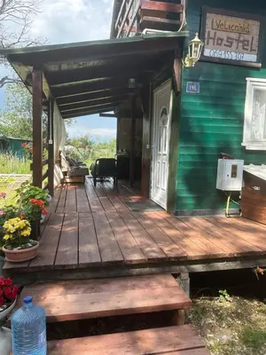 a porch of a house with a wooden deck at Velicanka hostel 2 in Kravlja