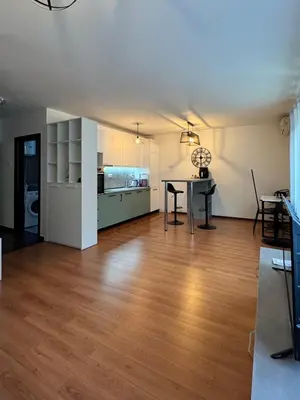 a living room with a table and a kitchen at Alex Apartment Petrovac in Petrovac na Moru