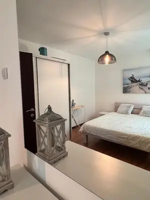 a white room with a bed and a mirror at Alex Apartment Petrovac in Petrovac na Moru