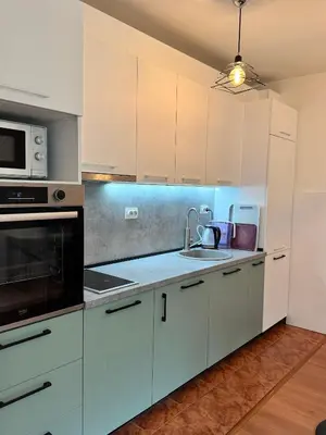a kitchen with white cabinets and a sink at Alex Apartment Petrovac in Petrovac na Moru