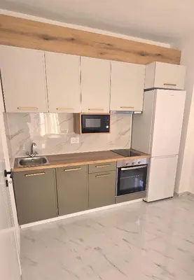 a kitchen with white cabinets and a sink and a refrigerator at Apartmani Banović 2 - Ulcinj, Velika plaža in Ulcinj