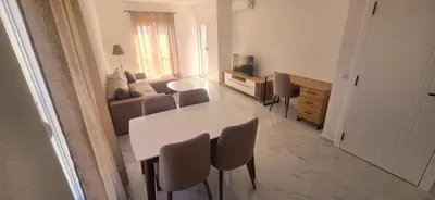 a living room with a white table and chairs at Apartmani Banović 2 - Ulcinj, Velika plaža in Ulcinj