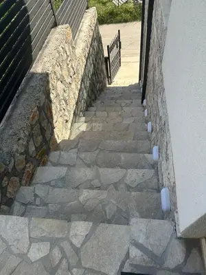 a stone wall next to a wall with a stairway at Villa Zaljevo in Bar