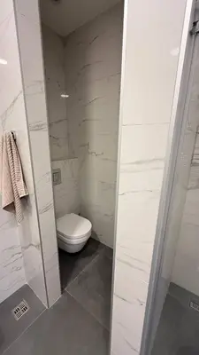 a white bathroom with a toilet and a shower at Soho Stay in Bar