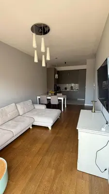 a living room with a white couch and a kitchen at Soho Stay in Bar