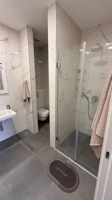 a bathroom with a shower and a toilet and a sink at Soho Stay in Bar