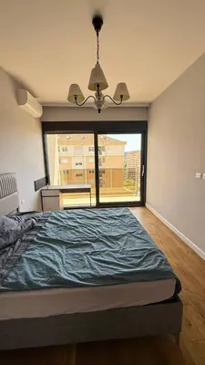a bedroom with a bed and a large window at Soho Stay in Bar