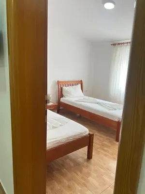 a room with two beds and a door open at Halili Apartments in Ulcinj