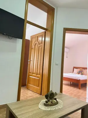 a room with a door and a table and a mirror at Halili Apartments in Ulcinj