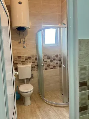 a small bathroom with a toilet and a shower at Halili Apartments in Ulcinj