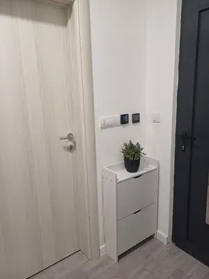 a white cabinet with a plant on it next to a door at Utjeha Hills with Pool in Bar