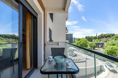 a table on a balcony with a view of a street at Summer Nest Studio in Becici in Becici