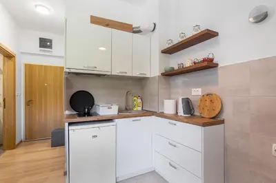 a kitchen with white cabinets and a wooden counter top at Summer Nest Studio in Becici in Becici
