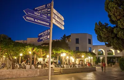a street sign with street signs on a pole at Hotel Slovenska Plaza in Budva
