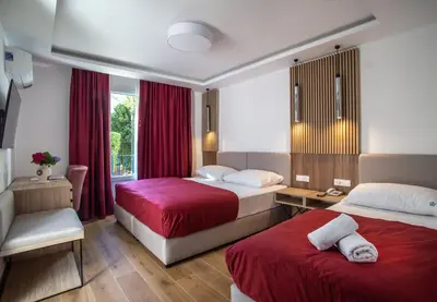 a hotel room with two beds and a window at Hotel Slovenska Plaza in Budva
