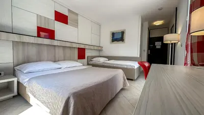 a hotel room with two beds and a table at Hotel Slovenska Plaza in Budva