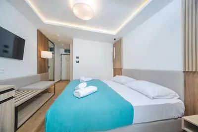 a bedroom with a large bed with towels on it at Hotel Slovenska Plaza in Budva