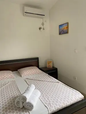 a bedroom with two beds with white sheets and towels at MARSHAL Apartments in Donji Štoj