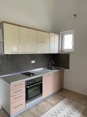 a kitchen with white cabinets and a sink and a stove at MARSHAL Apartments in Donji Štoj
