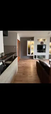 a large room with a kitchen with a wooden floor at Uživajte u mirnom i elegantnom smještaju in Podgorica