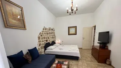 a bedroom with a bed and a couch and a tv at Royal House in Kotor