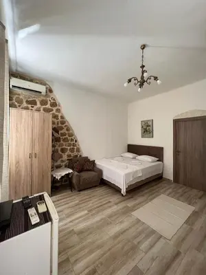 a bedroom with a bed and a chair in a room at Royal House in Kotor