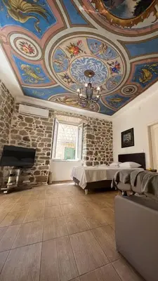 a large room with a ceiling with paintings on it at Royal House in Kotor