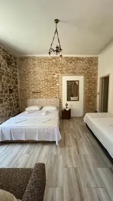 a bedroom with two beds and a brick wall at Royal House in Kotor