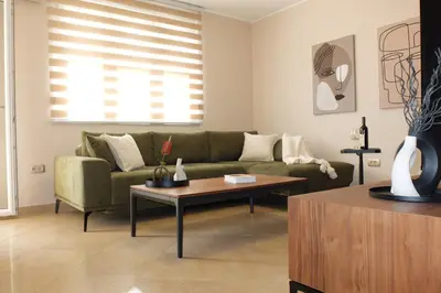 a living room with a green couch and a table at Modern 1BR - Old Town and sea in Budva