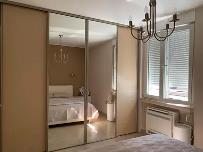 a mirror in a bedroom with a bed and a window at Modern 1BR - Old Town and sea in Budva