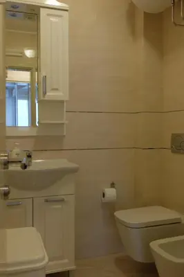 a bathroom with a sink and a toilet and a mirror at Modern 1BR - Old Town and sea in Budva