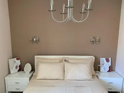 a bedroom with a bed with a chandelier above it at Modern 1BR - Old Town and sea in Budva