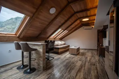 a living room with a vaulted ceilings and a large window at Agape Apartments in Kotor