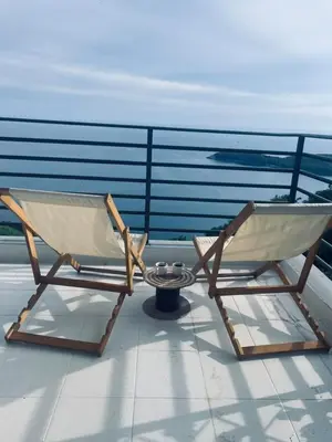 a pair of folding chairs sitting on a balcony at Apartman Magdalena in Seoca