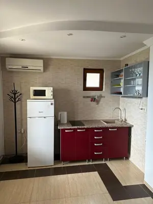 a kitchen with a white refrigerator and red cabinets at Tri bora in Bar