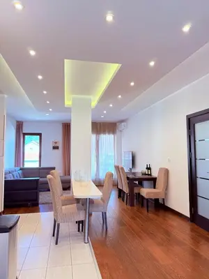 a living room with a table and chairs and a couch at Apartment in the Lusitanos in Budva