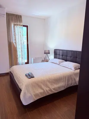 a bedroom with a large bed with a large window at Apartment in the Lusitanos in Budva