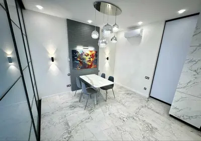 a dining room with a table and chairs and a painting at Apartman Velsma in Budva