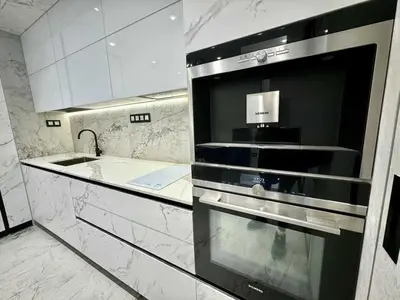 a kitchen with white marble counters and a sink at Apartman Velsma in Budva