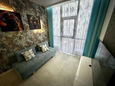 a living room with a couch and a window at Apartman Velsma in Budva