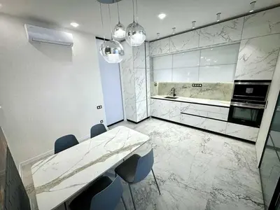 a kitchen with a marble table and chairs in it at Apartman Velsma in Budva