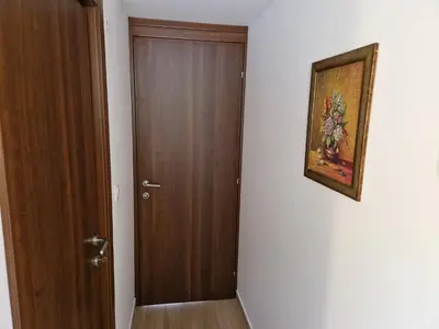 a hallway with a wooden door and a painting on the wall at Villa Bougainvilla in Becici