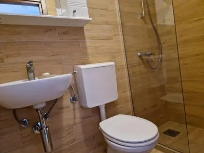 a bathroom with a toilet and a sink and a shower at Villa Bougainvilla in Becici