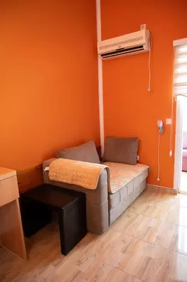 a bed in a room with an orange wall at apartmani DENI in Donji Štoj