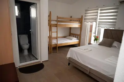 a bedroom with a bed and a bathroom with a toilet at apartmani DENI in Donji Štoj