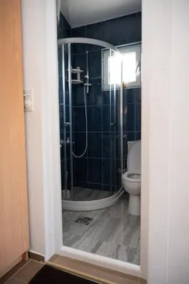 a bathroom with a shower and a toilet at apartmani DENI in Donji Štoj