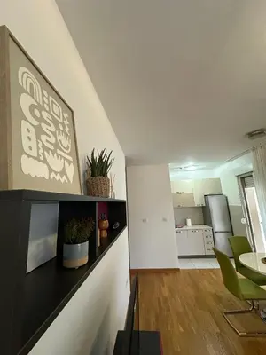 a kitchen and living room with a table and chairs at District Loft in Podgorica