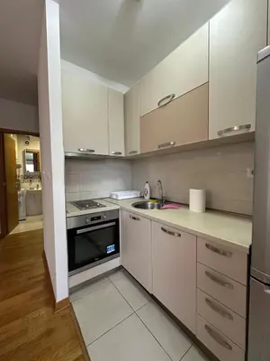 a kitchen with white cabinets and a stove top oven at District Loft in Podgorica