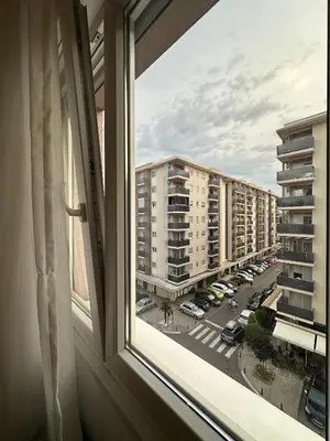 a window with a view of a street and buildings at District Loft in Podgorica